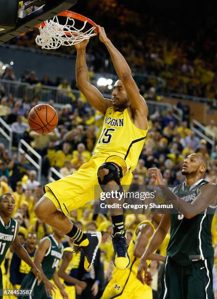 Jon Horford of the Michigan Wolverines gets in for a second half dunk in front of Adreian Payne of the Michigan State Spartans at Crisler Center on...