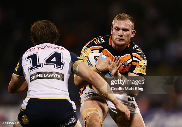 Matthew Lodge of the Tigers runs at Rory Kostjasyn of the Cowboys during the round 11 NRL match between the Wests Tigers and the North Queensland...