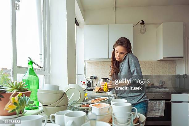 mujer lavando platos - messy fotografías e imágenes de stock