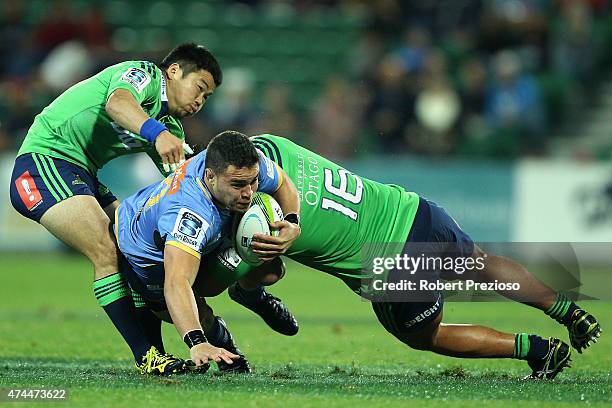 Kane Koteka of the Force is tackled by Fumiaki Tanaka of the Highlanders and Ash Dixon of the Highlanders during the Super Rugby round 15 match...