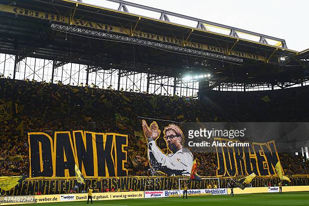 Fans of Dortmund hold up a banner for their team's head coach Juergen Klopp reading 'Thank you Juergen' prior to the Bundesliga match between...
