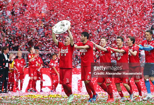 Bastian Schweinsteiger of Bayern Muenchen and teammates celebtrate with the trophy after winning the league during the Bundesliga match between FC...