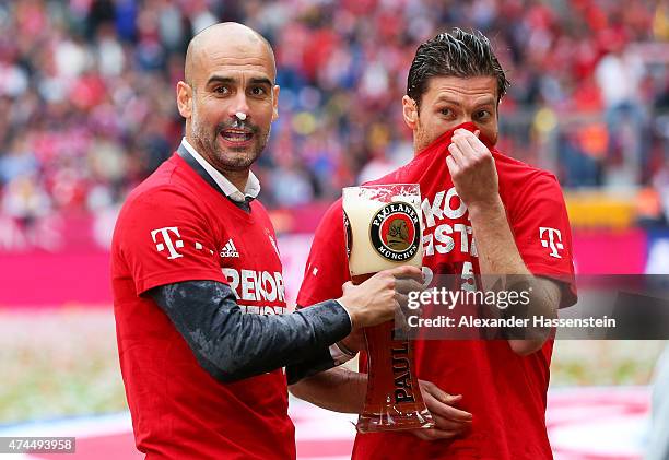 Josep Guardiola the head coach of Bayern Muenchen and Xabi Alonso of Bayern Muenchen celebrate winning the league following the Bundesliga match...