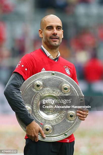 Josep Guardiola the head coach of Bayern Muenchen celebrates with the trophy after winning the league during the Bundesliga match between FC Bayern...