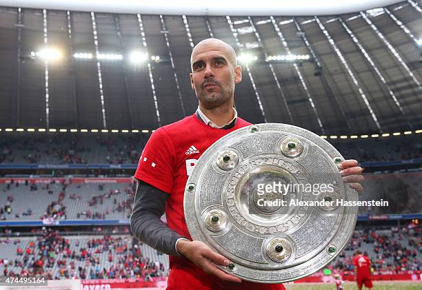 Josep Guardiola the head coach of Bayern Muenchen celebrates with the trophy after winning the league during the Bundesliga match between FC Bayern...