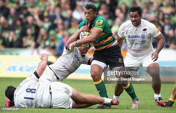 Jacques Burger and Juan Figallo of Saracens tackle Luther Burrell during the Aviva Premiership play off semi final match between Northampton Saints...