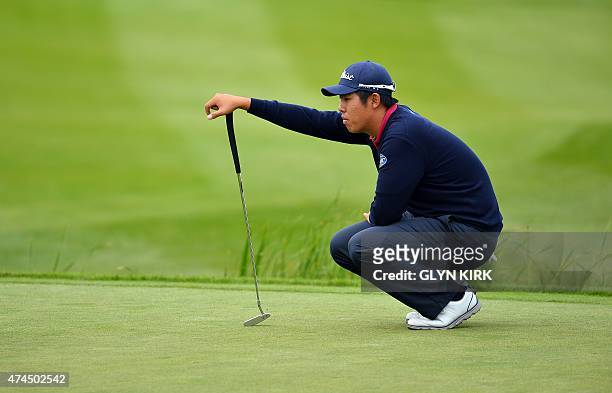 Korean golfer Byeong Hun An lines up his putt on the 18th green on the third day of the BMW PGA Championship at Wentworth Golf Club in Surrey, south...