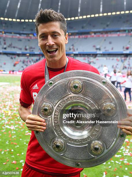 Robert Lewandowski of Bayern Muenchen celebrates with the trophjy after winning the league during the Bundesliga match between FC Bayern Muenchen and...
