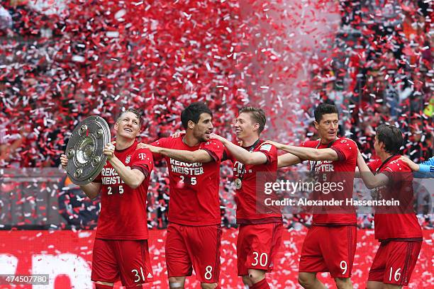 Bastian Schweinsteiger of Bayern Muenchen and teammates celebtrate with the trophy after winning the league during the Bundesliga match between FC...