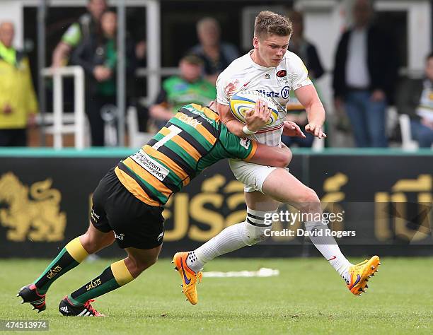 Owen Farrell of Saracens is tackled by Calum Clarke during the Aviva Premiership play off semi final match between Northampton Saints and Saracens at...