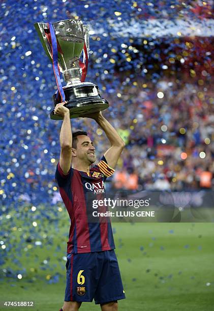 Barcelona's midfielder Xavi Hernandez holds up the trophy for the Spanish league title of 2014/15 after the Spanish league football match FC...