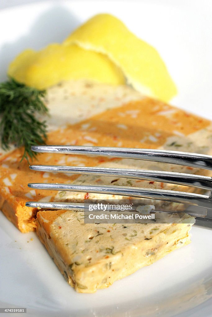 Fish terrine with fork, lemon and dill.