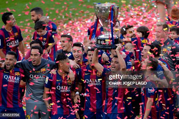 Barcelona's midfielder Xavi Hernandez holds the Spanish League 2014/15 trophy after winning the Spanish league football match FC Barcelona vs RC...