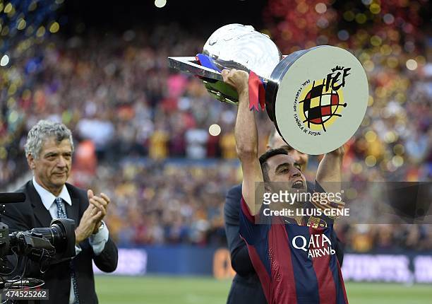 Barcelona's midfielder Xavi Hernandez holds up the trophy for the Spanish league title of 2014/15 as president of Spanish Football Association Angel...