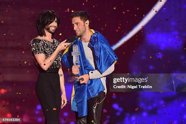 Conchita Wurst hands over the trophy to Mans Zelmerloew of Sweden after winning the final of the Eurovision Song Contest 2015 on May 23, 2015 in...