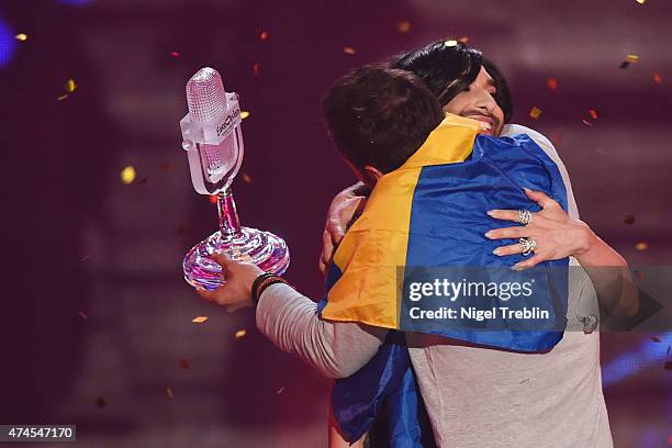 Conchita Wurst hands over the trophy to Mans Zelmerloew of Sweden after winning the final of the Eurovision Song Contest 2015 on May 23, 2015 in...