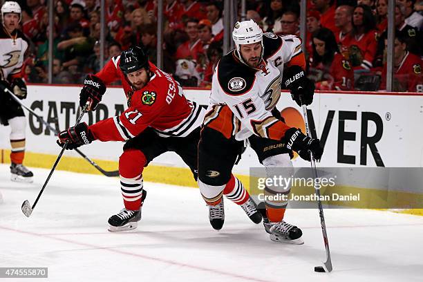 Ryan Getzlaf of the Anaheim Ducks skates with the puck in the second period as Andrew Desjardins of the Chicago Blackhawks defends in Game Four of...