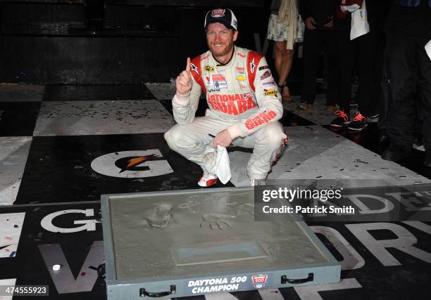 Dale Earnhardt Jr., driver of the National Guard Chevrolet, poses after putting his handprints in cement in Victory Lane after winning the NASCAR...