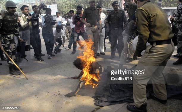 Indian police extinguish the flames as Pranab Boro, an activist of Krisak Mukti Sangram Samiti self-immolates in a protest demanding land rights for...