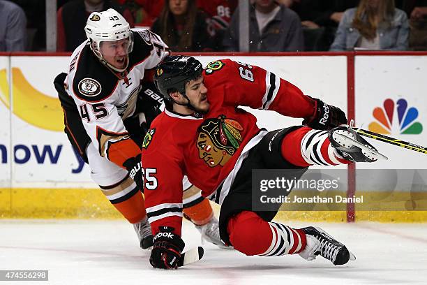 Andrew Shaw of the Chicago Blackhawks trips while going for a puck against Sami Vatanen of the Anaheim Ducks in the second period of Game Four of the...