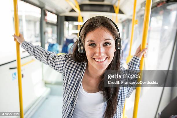 若い幸せな女性、耳の電話、バス - people using public transport ストックフォトと画像
