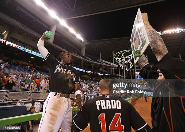 Dee Gordon of the Miami Marlins dunks a toy basketball over Martin Prado into a hoop held by Mat Latos after Prado hit a walk-off single to win the...