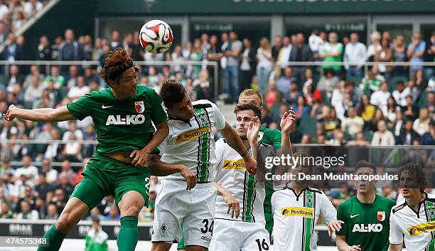 Granit Xhaka of Borussia Moenchengladbach and Hong Jeong-Ho of FC Augsburg battle for the header during the Bundesliga match between Borussia...