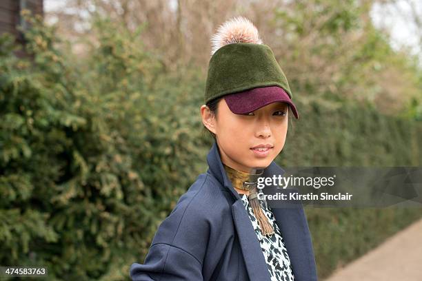 Blogger Margaret Zhang wears a Whistles coat and top Preston and Olivia hat and ManiaMania necklace on day 4 of London Collections: Women on February...