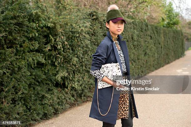 Blogger Margaret Zhang wears a Whistles coat, bag, top and skirt, Preston and Olivia hat, River Island trousers and ManiaMania necklace on day 4 of...