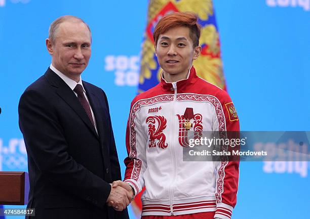 Russian President Vladimir Putin shakes hands with Olympic gold medalist in speed skating Viktor Ahn after presenting him with an award during an...