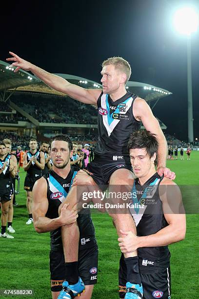 Kane Cornes of the Power is carried off the field by Travis Boak of the Power and Angus Monfries of the Power after his 300th and final game during...