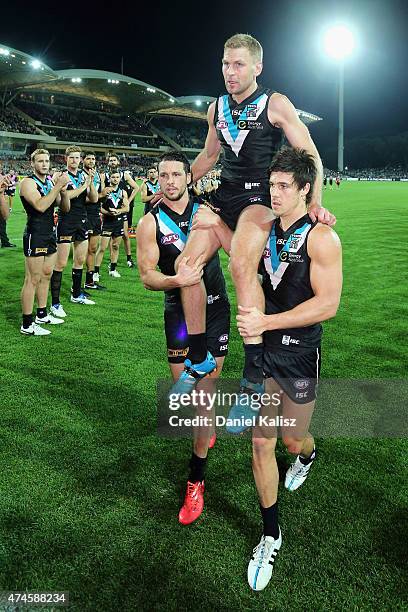 Kane Cornes of the Power is carried off the field by Travis Boak of the Power and Angus Monfries of the Power after his 300th and final game during...