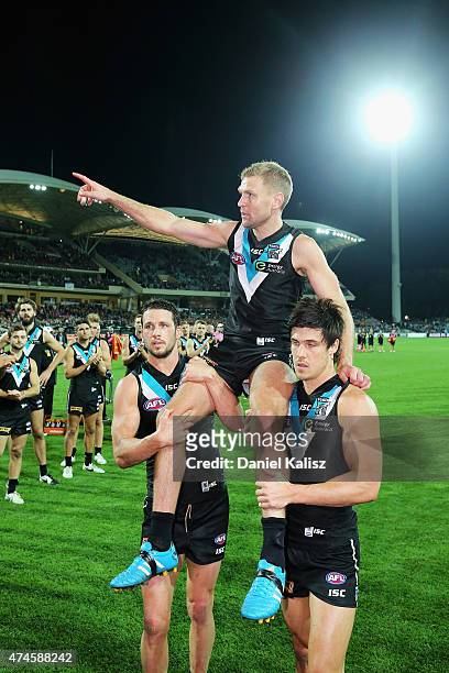 Kane Cornes of the Power is carried off the field by Travis Boak of the Power and Angus Monfries of the Power after his 300th and final game during...