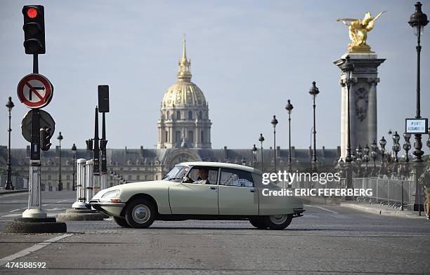 Citroen DS drives in front of Les Invalides in Paris on May 24, 2015 as the legendary French car celebrates its 60th anniversary. AFP PHOTO / ERIC...