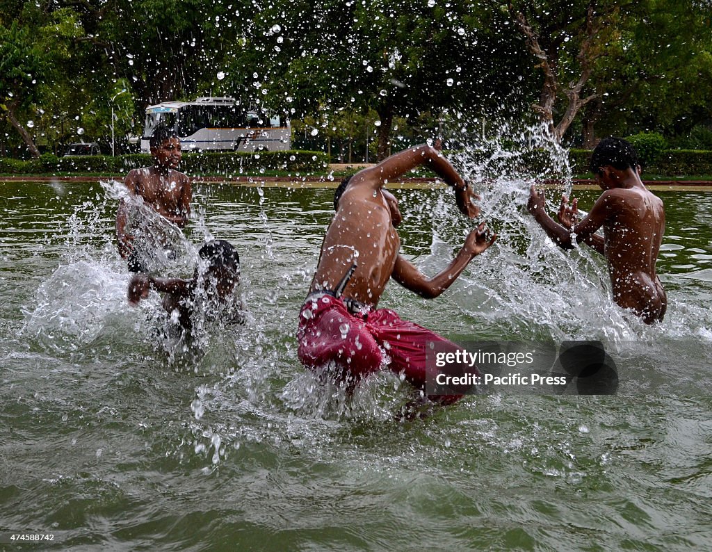 Children taking a bath at India Gate Water Pond  during a...