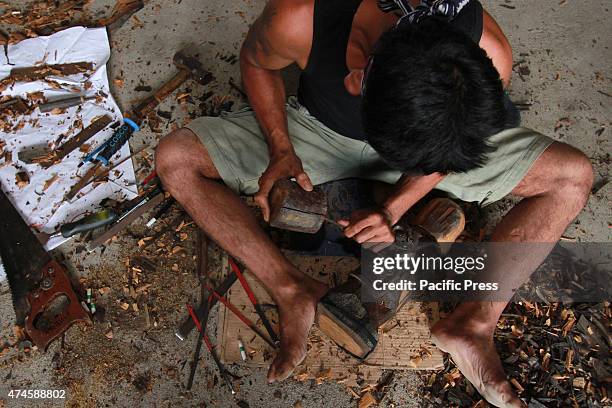 The craftsman of Dayak competing to curve and paint shields, using real wood material of Borneo's best quality called Belian, during the "Gawai Dayak...