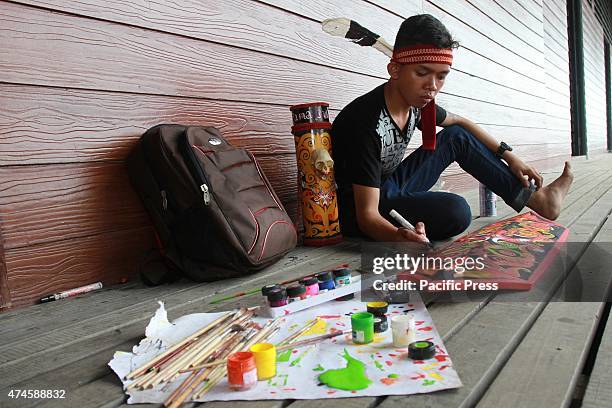 The craftsman of Dayak competing to curve and paint shields, using real wood material of Borneo's best quality called Belian, during the "Gawai Dayak...