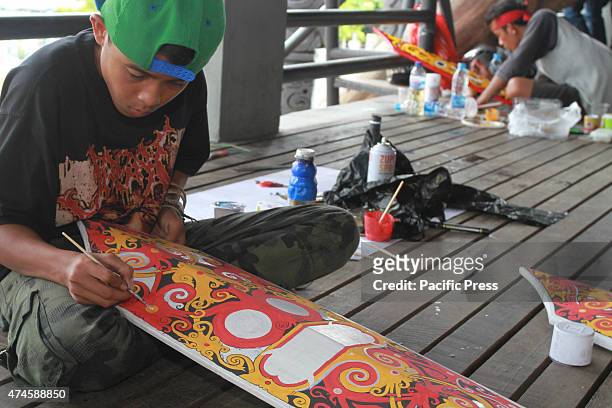 The craftsman of Dayak competing to curve and paint shields, using real wood material of Borneo's best quality called Belian, during the "Gawai Dayak...