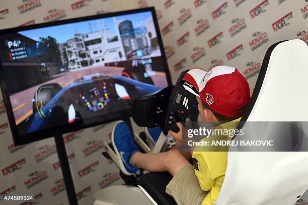 Boy plays a Formula One video game in a simulation racing seat at the Monaco street circuit in Monte-Carlo on May 24 before the Monaco Formula One...