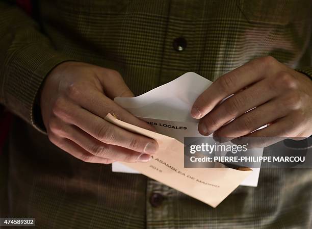 Man prepares his ballots in Spain's municipal and regional pelections at a polling station in Madrid on May 24, 2015. Polls opened at 9:00 am , with...