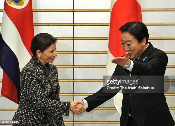 Costa Rican President Laura Chinchilla and Japanese Prime Minister Yoshihiko Noda shake hands prior to their meeting at Noda's official residence on...