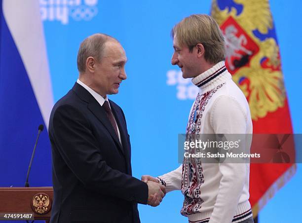 Russian President Vladimir Putin shakes hands with Olympic gold medalist in figure skating Evgeni Plushenko after presenting him with an award during...