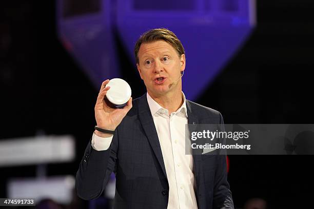 Hans Vestberg, chief executive officer of Ericsson AB, speaks while holding a mobile device during a news conference on the opening day of the Mobile...