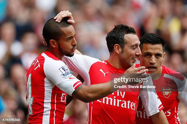 Theo Walcott of Arsenal scores his team's first goal with his team mates Santi Cazorla and Alexis Sanchez during the Barclays Premier League match...