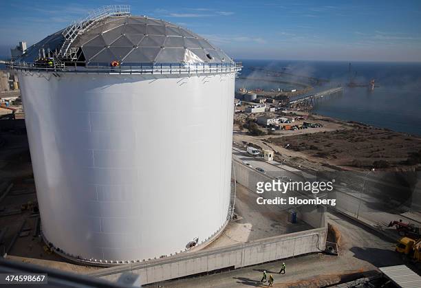 Construction worker stands on a walkway on top of a fuel storage tank at the VTTV oil storage terminal, a joint venture of Vitol Group and MISC Bhd.,...