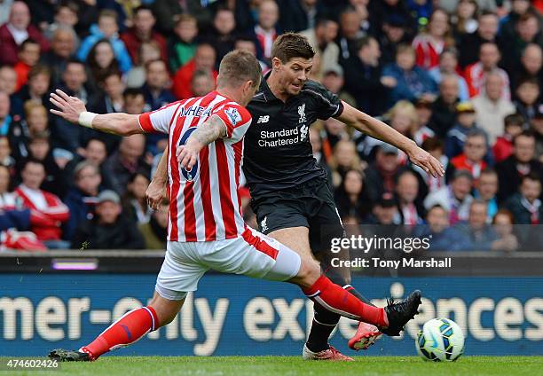 Glenn Whelan of Stoke City tackles Steven Gerrard of Liverpool during the Barclays Premier League match between Stoke City and Liverpool at Britannia...