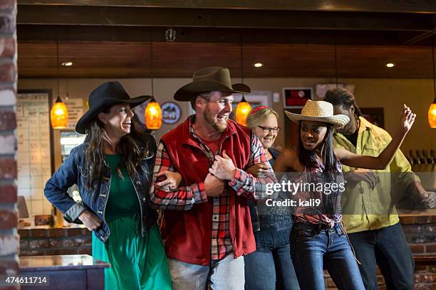 groupe multi-ethnique d'amis danser dans un bar - cow boy photos et images de collection