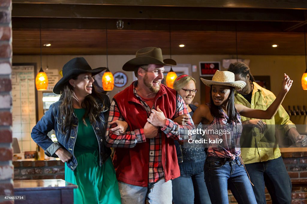 Multi-ethnic group of friends dancing in a bar