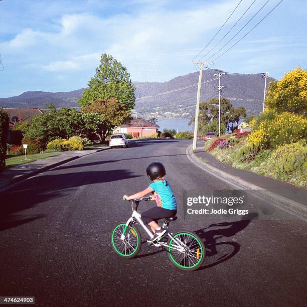 child riding bicycle along suburban street - australia street stockfoto's en -beelden