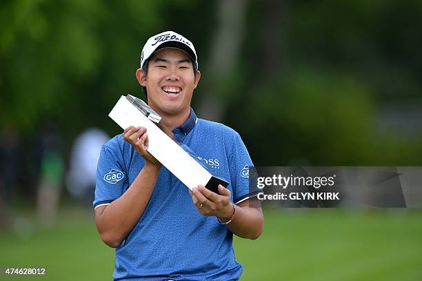 Korean golfer Byeong-hun An celebrates with the trophy after winning the PGA Championship at Wentworth Golf Club in Surrey, south west of London on...